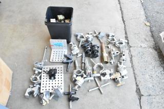 Lot of various clamps and grip gear in a black poly bin. Includes metal brackets and attachments. Mixed condition.