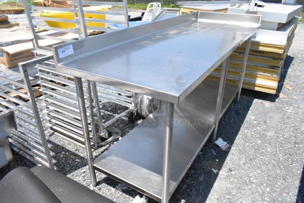 Stainless steel table with under shelf and back splash, showing light wear. Includes auction tag numbered 437.
