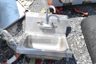 Stainless steel wall mount sink with faucet and dual handles, single bay, good condition, visible label "4329".