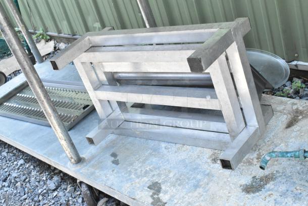 Stainless steel table with under shelf, includes dunnage racks and metal pans. Good condition, for commercial use.