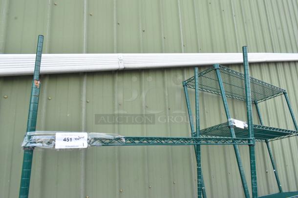 Green 3-tier wire shelving unit on commercial casters, slightly rusted, buyer must dismantle. Tags indicate auction lot number.