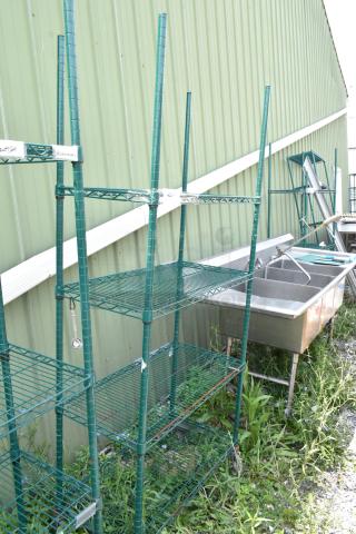 Green 4-tier wire shelving unit on commercial casters, adjustable height, outdoors, dismantling required for transport.