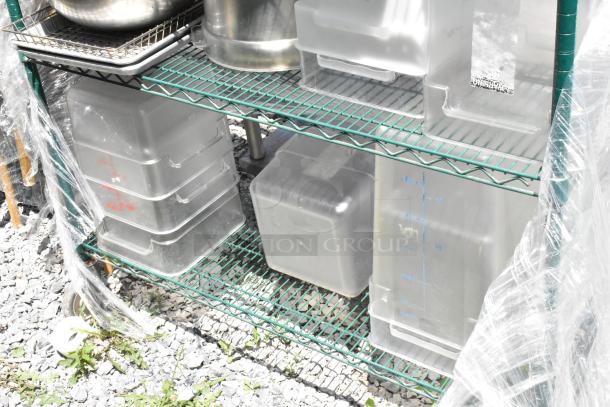 Green 4-tier wire shelving unit on casters, includes stainless and poly bins. Buyer must dismantle for shipping.