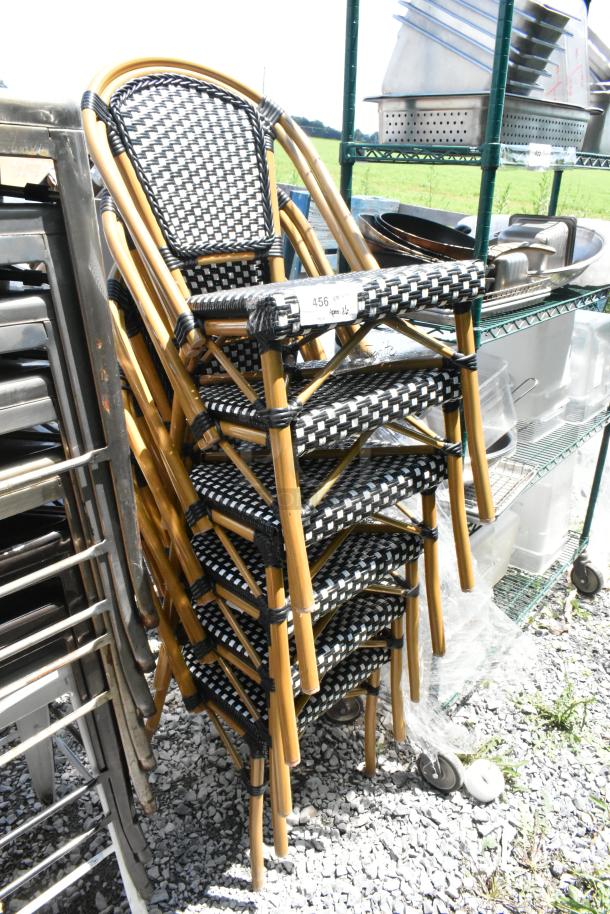 6 new wicker-style patio chairs, stackable. Brown frame with black and white woven seat. Scratch and dent condition.