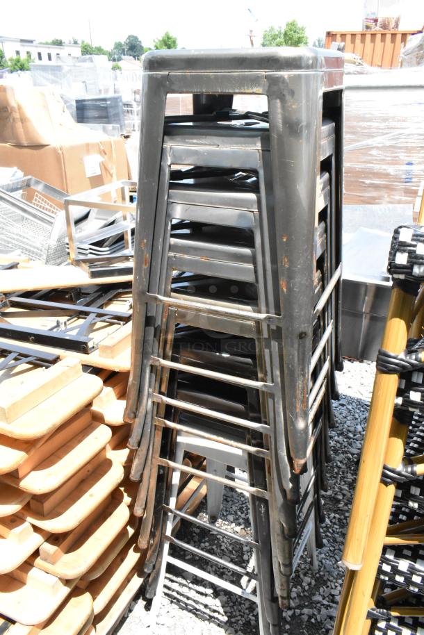 8 stackable metal Tolix-style stools, industrial design, visibly worn with surface rust, ideal for commercial use.