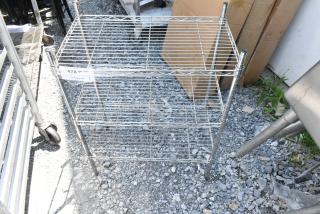Chrome finish 3-tier wire shelving unit, visible label with PCIauctions.com. Buyer must dismantle. Consider freight charges.
