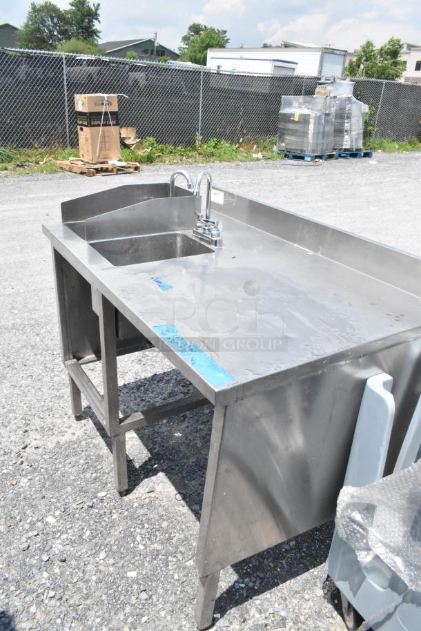 Stainless steel table with two single sink bays, faucets, and handles, in good condition, ideal for commercial use.