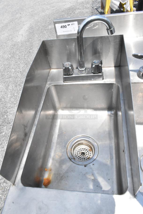 Stainless steel table with two single sink bays, featuring faucets and handles. Visible wear; numbered tag "490."