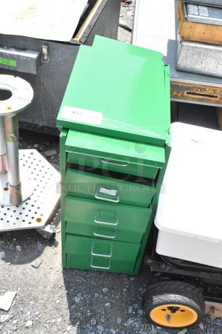 Green metal filing cabinet with five drawers, labeled "493," slight surface scratches, sturdy handles, and visible in outdoor setting.