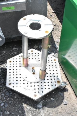 Metal unit on commercial casters with circular platform and hexagonal perforated base. Industrial use, sturdy construction.