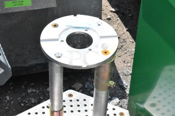 Metal unit on commercial casters with a circular top plate, sturdy metal legs, and visible "Not For Lifting" label. In good condition.