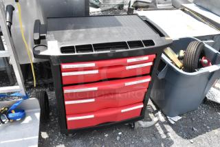 Black and red poly cart on commercial casters, featuring labeled storage drawers for organization; used condition.