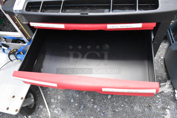 Black and red poly cart with open drawers, labeled for organization. Features commercial casters for mobility, in good condition.