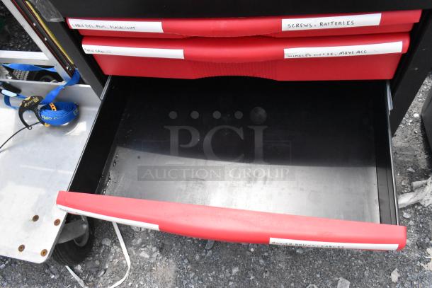 Black and red poly cart on commercial casters with labeled red drawers for organization. Sturdy and functional design.