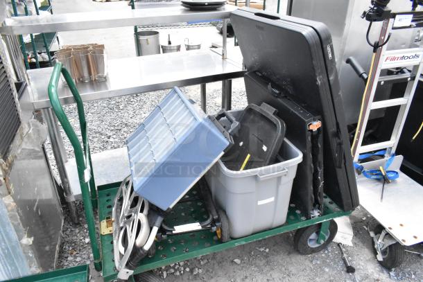 Green metal flat cart carrying a folded table and gray poly bin. Includes a blue organizer. Good condition.