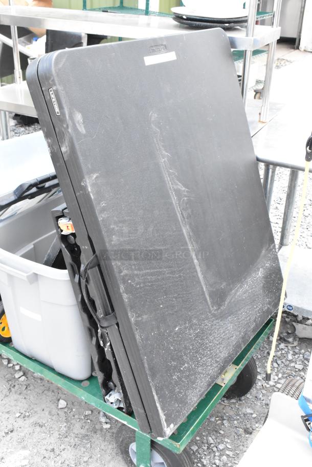 Green metal flat cart with large folding table and poly bin. Cart in used condition with visible wear on contents.
