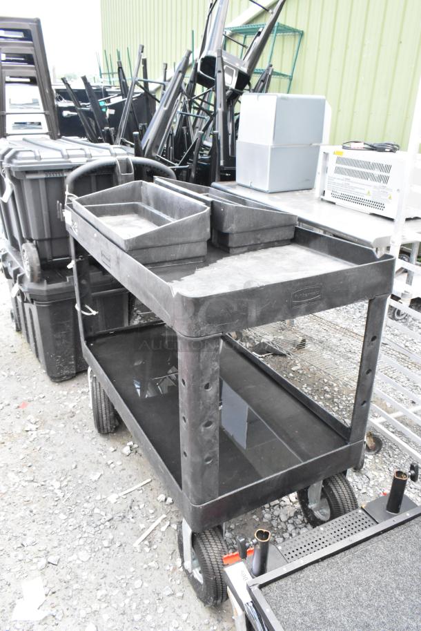 Black poly 2-tier cart on casters, sturdy construction with upper and lower shelves, textured surface, in good condition.