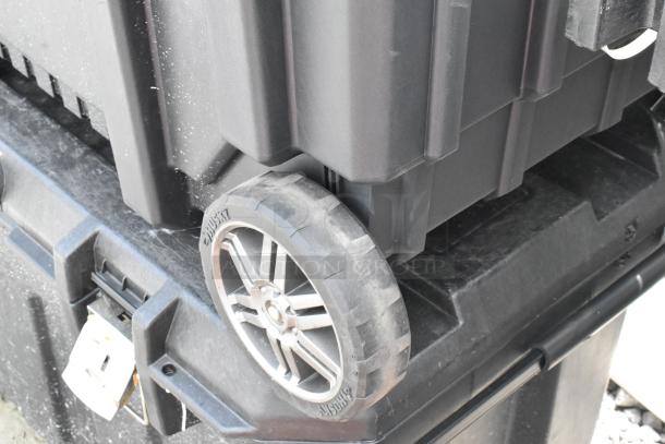 Husky black poly case on casters, sturdy build, with visible Husky branding on the wheels, ideal for tool storage.