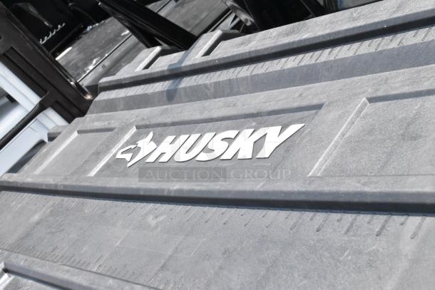 Husky black poly case on casters with embossed logo. Durable construction, ideal for secure storage and easy transport.