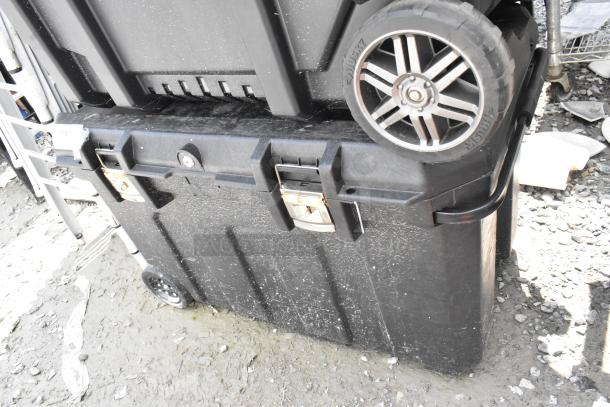 Stanley black poly case on casters, robust design, dual locks, visible wear, ideal for secure storage and transport.