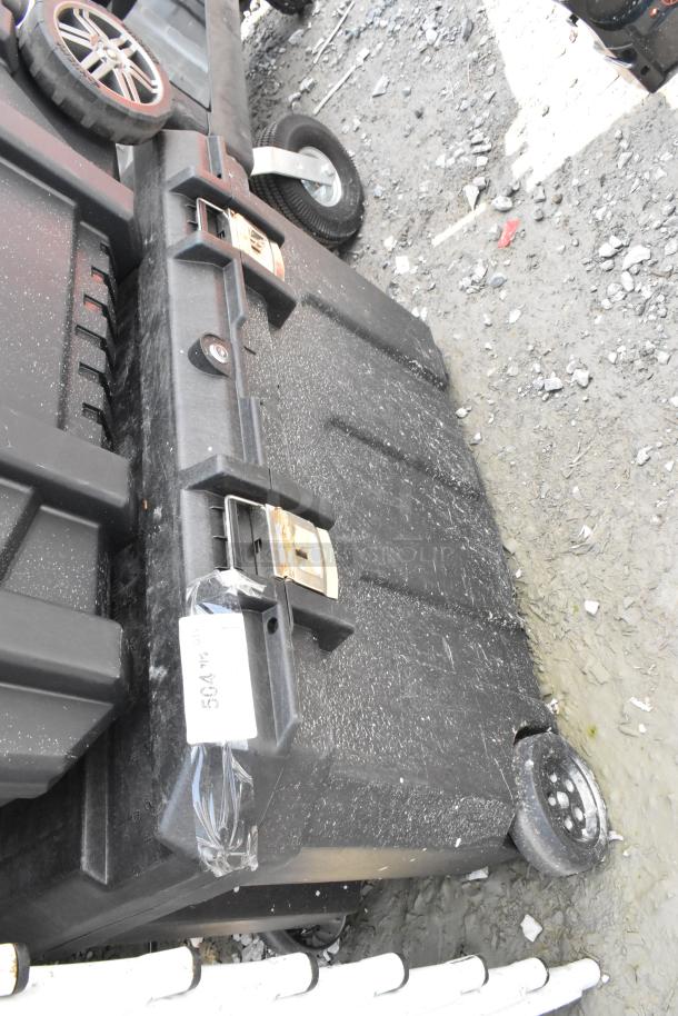 Stanley black poly case on casters, visible wear, dusty surface, featuring handles and latches. Label displays "504-WO."