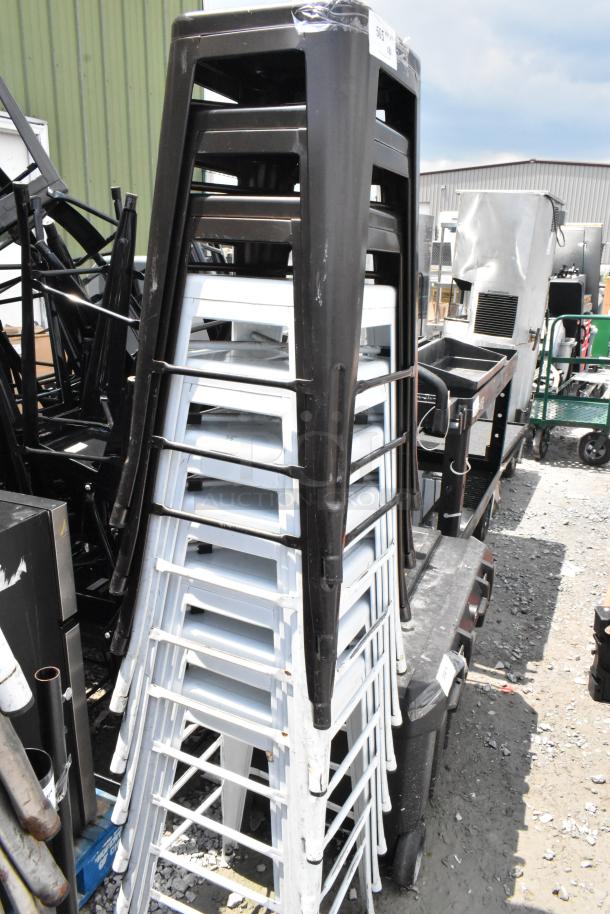 Stack of 10 metal Tolix style bar stools, mix of black and white. Some visible wear. Sold as a bundle, boosting bid value.