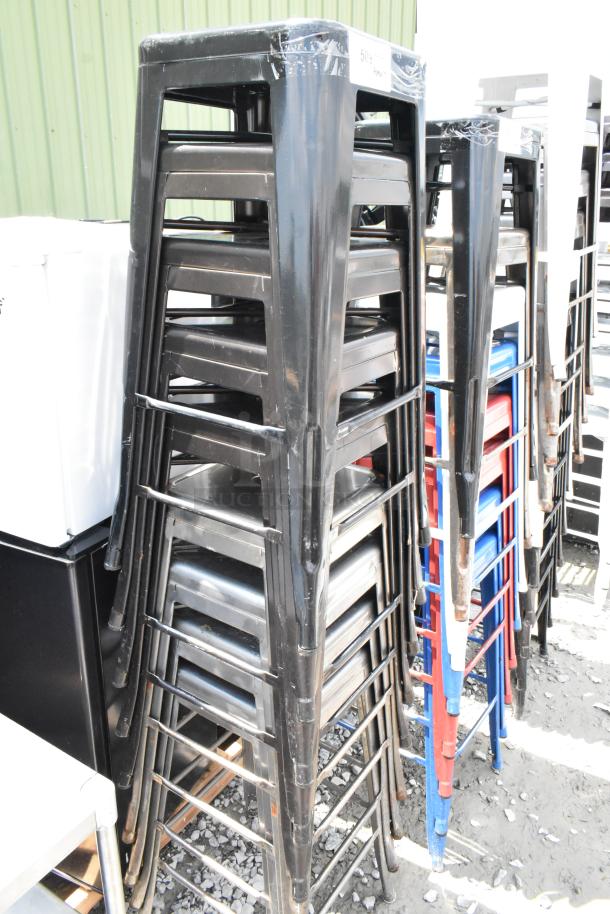 9 black metal Tolix style bar stools, stackable, bar height, lightly worn, suitable for indoor or outdoor use.
