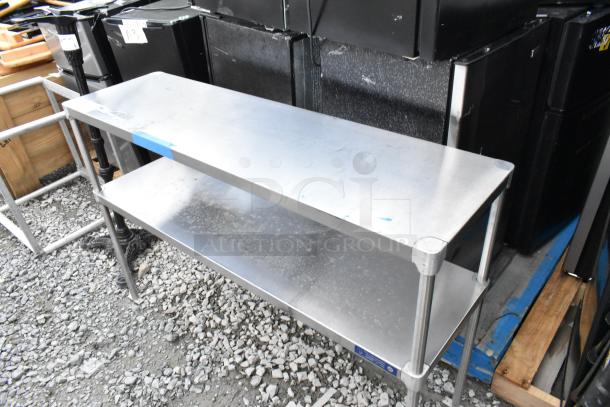 Stainless steel 2-tier over shelf, showing light wear. Ideal for kitchen storage, sturdy design, visible minor scuffs on surface.