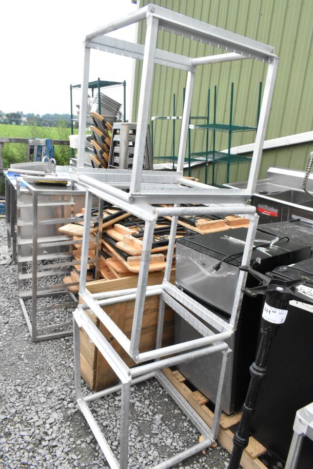 Three metal pan rack frames, sturdy construction, used condition, ideal for storage or organization in kitchen settings.