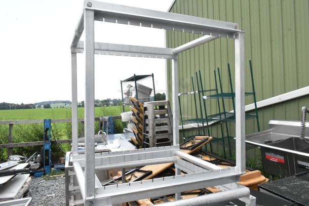 Metal pan rack frame, sturdy construction, outdoor setting, used condition, additional racks in background.