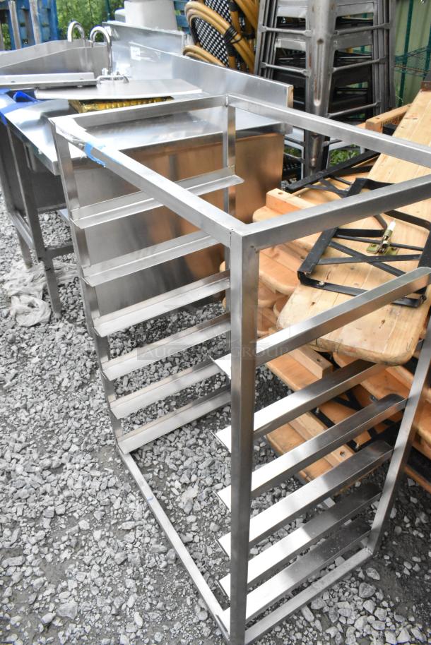 Stainless steel metal pan rack with multiple horizontal slots, in good condition. Suitable for organizing kitchenware.