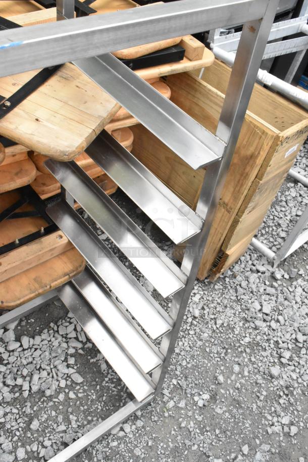 Metal pan rack with multiple shelves, sturdy design, good condition, used for organizing kitchenware.