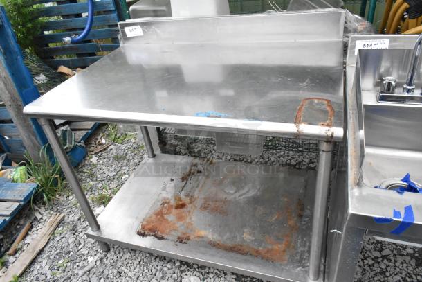 Stainless steel table with under shelf and backsplash, visible rust on surfaces, overall used condition.