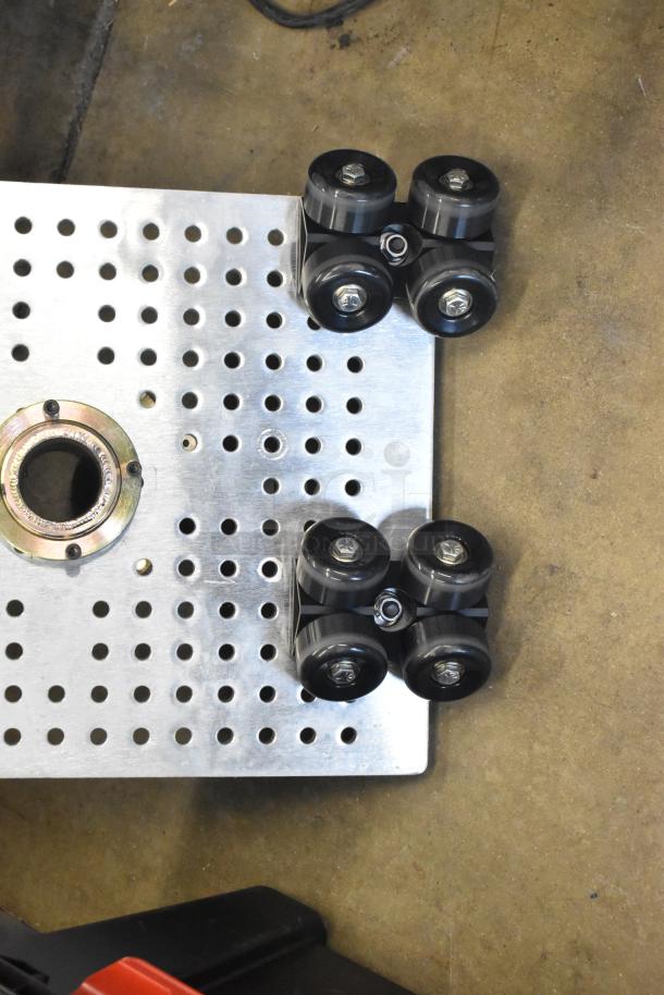Alt text: Movi Elevator rollers and perforated metal plate in poly bin, showing black wheels and durable construction.