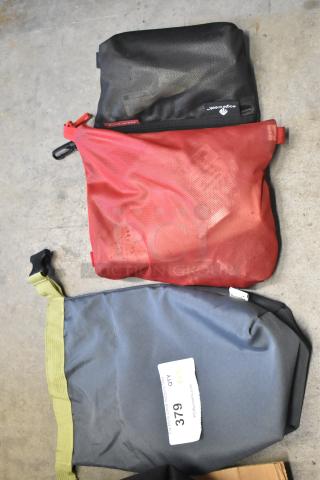 Three assorted fabric bags, including black, red, and gray, each with unique contents. Marked "379" for auction.