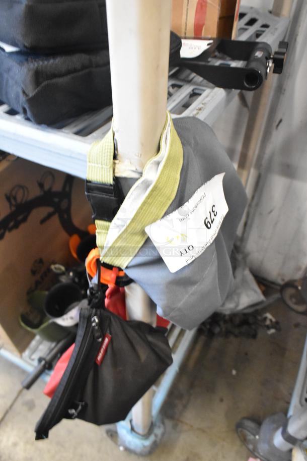 Three bags hung on a rack, assorted contents included. Auction label with lot number 379 attached. Good condition.