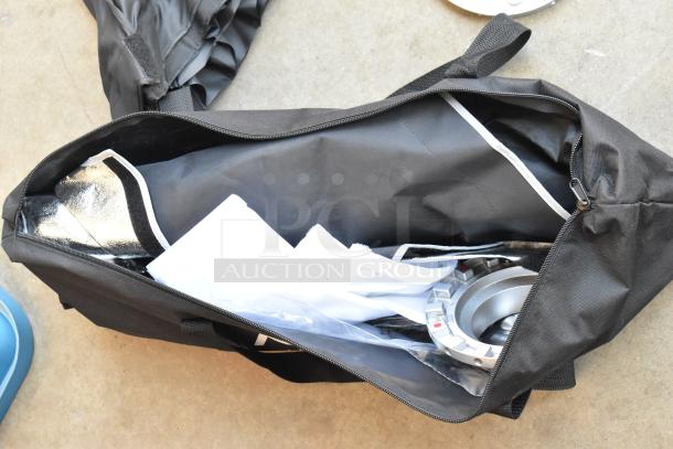 Poly bin containing various items, including Impact Aputure gear, in a black zippered bag with visible metal fixture and fabric materials.