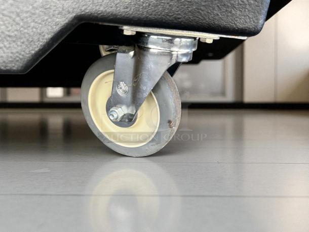 Caster wheel of a Cambro BAR540DS portable bar, showing durable construction in excellent condition, suitable for easy mobility.