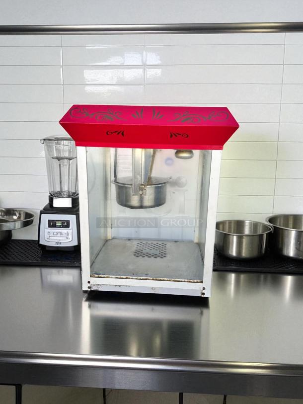 Vintage-style commercial popcorn machine in excellent condition, fully tested and working, with decorative red top.