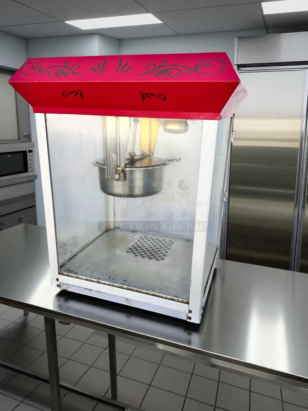Vintage-style commercial popcorn machine in excellent condition; fully tested and working, featuring a decorative red top.