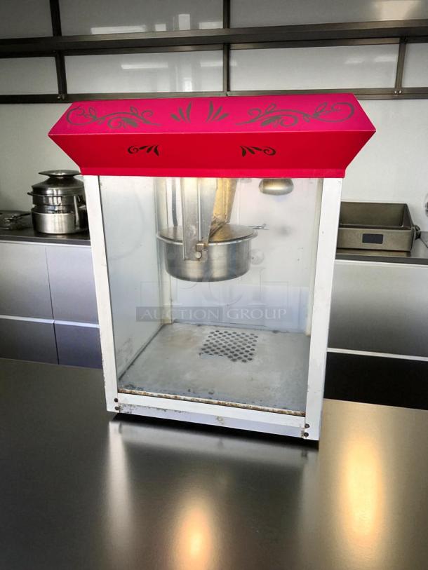 Vintage-style commercial popcorn machine in excellent condition; red top with decorative design, fully tested and working.