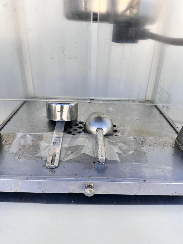 Vintage-style commercial popcorn machine in excellent condition, fully tested and working, with measuring tools included.