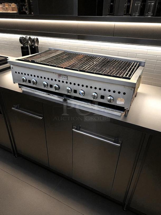 Wolf 48" gas countertop radiant charbroiler in excellent condition, featuring multiple control knobs and durable metal construction.