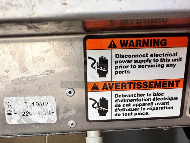 EquipEx 400E crepe maker underside with warning label. Indicates electrical disconnection needed before servicing. 220V, 50Hz marked.