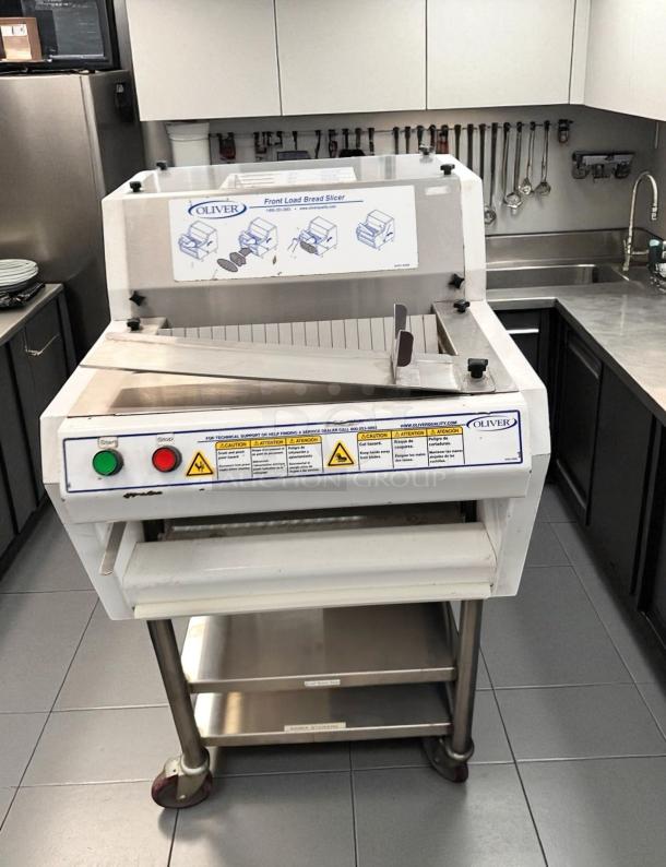 Oliver 702N front load bread slicer in excellent condition, 115V, fully tested and working, features operational buttons and safety labels.