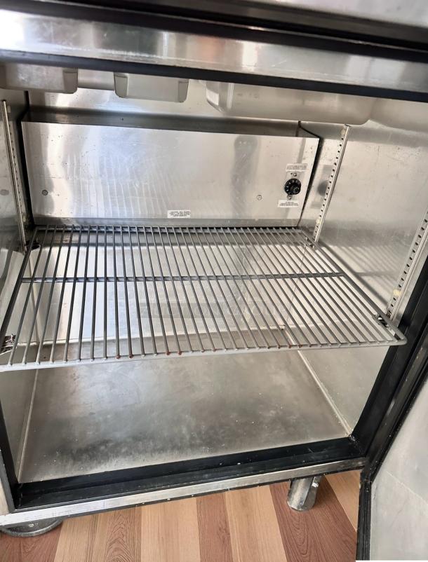 True TSSU-27-08 sandwich prep table in excellent condition, interior view. Features include a 27" width, single door, and 115V.