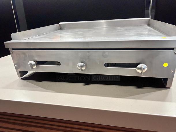 36" commercial flat top griddle in outstanding working condition, tested, stainless steel, with control knobs and safety edges.