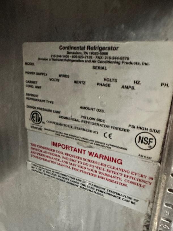 Alt text: Continental Refrigerator label on stainless steel prep table, showing model details, NSF certification, and maintenance warning.