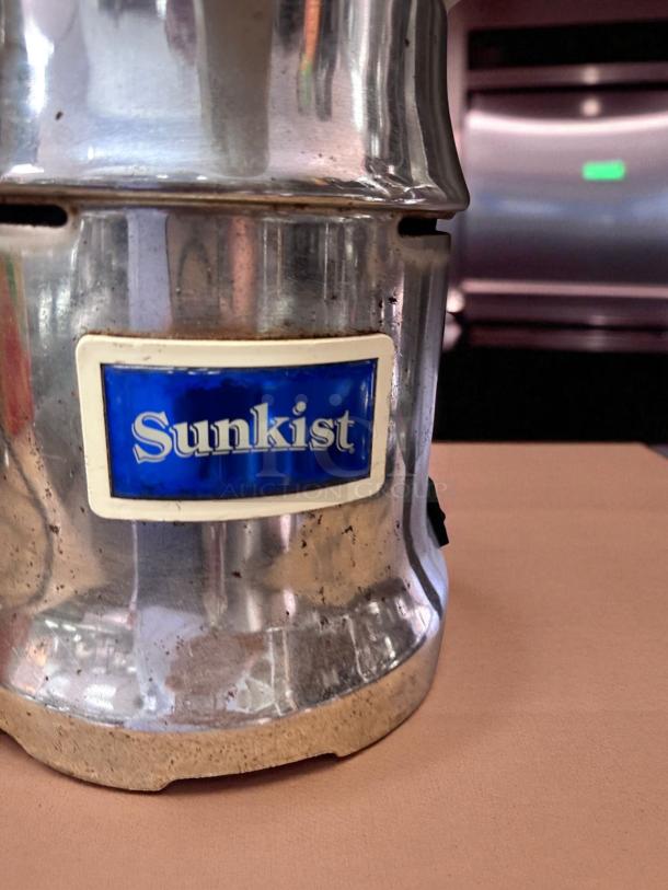 Sunkist 8R AOZ commercial juice extractor, polished metal finish, labeled "Sunkist," excellent condition, 115V, fully tested.