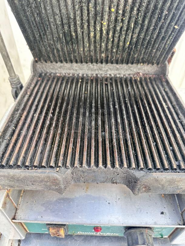 Waring Panini Perfetto in working condition. Ribbed grill plates, tested and functional. Model label visible.